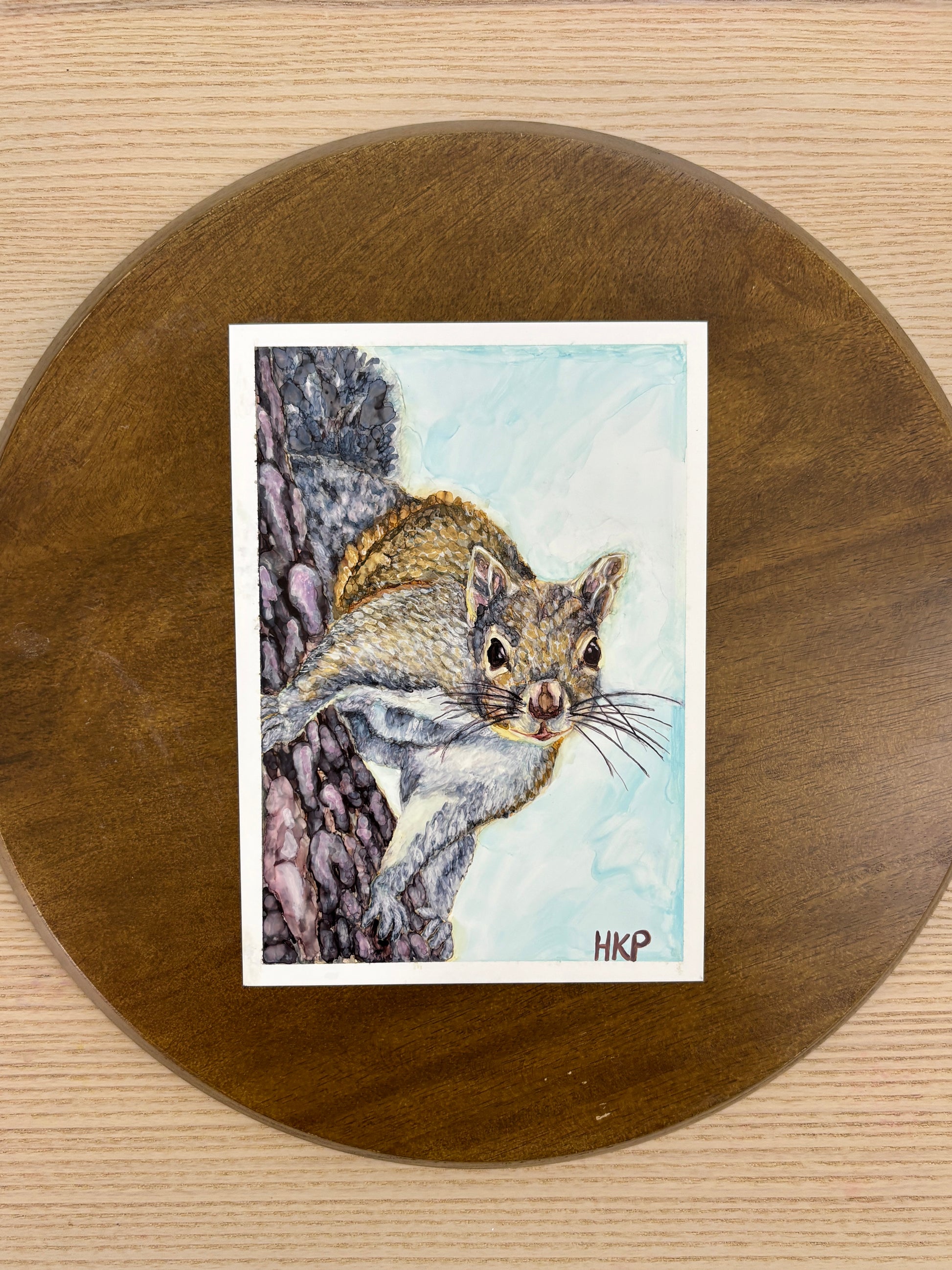 Painting of a squirrel displayed on a wooden plate